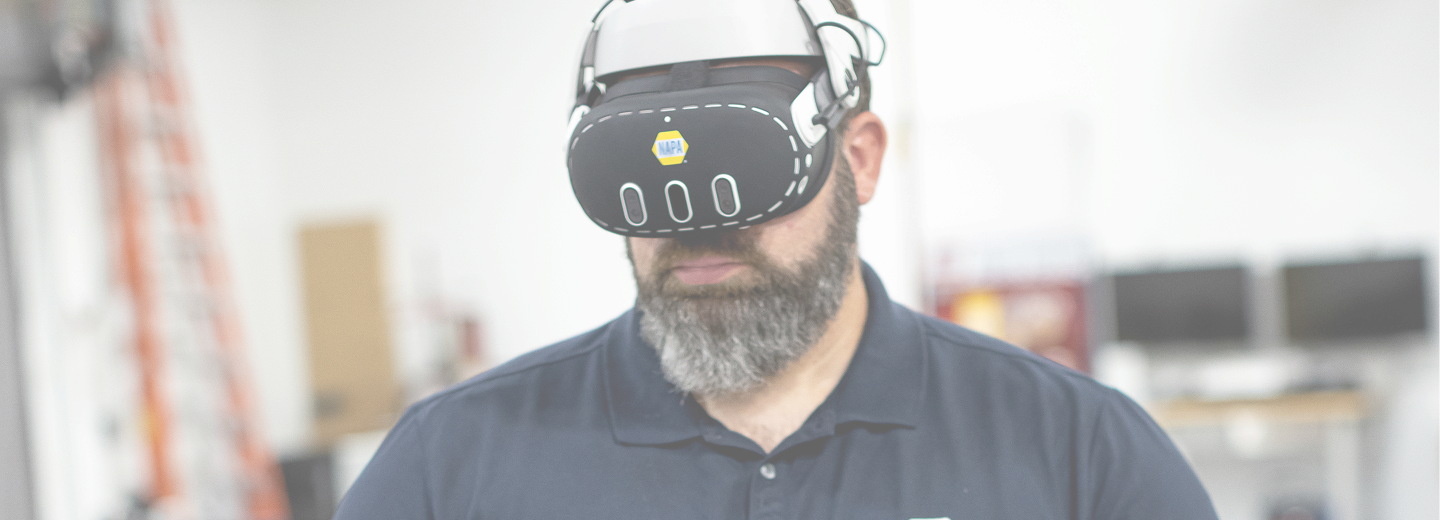Automotive technician wearing a virtual reality headset during immersive training in an automotive workshop.