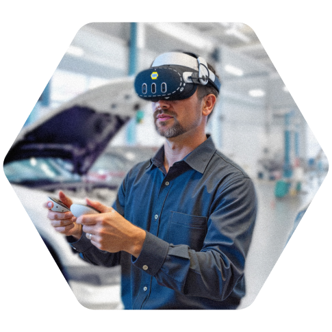 Person wearing XR Training Goggles and holding VR controllers during automotive training, with a vehicle in the background.