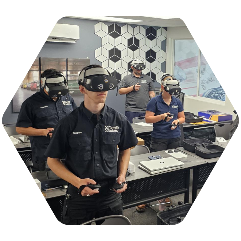 Group of automotive technicians wearing virtual reality headsets and using controllers during training in a classroom.